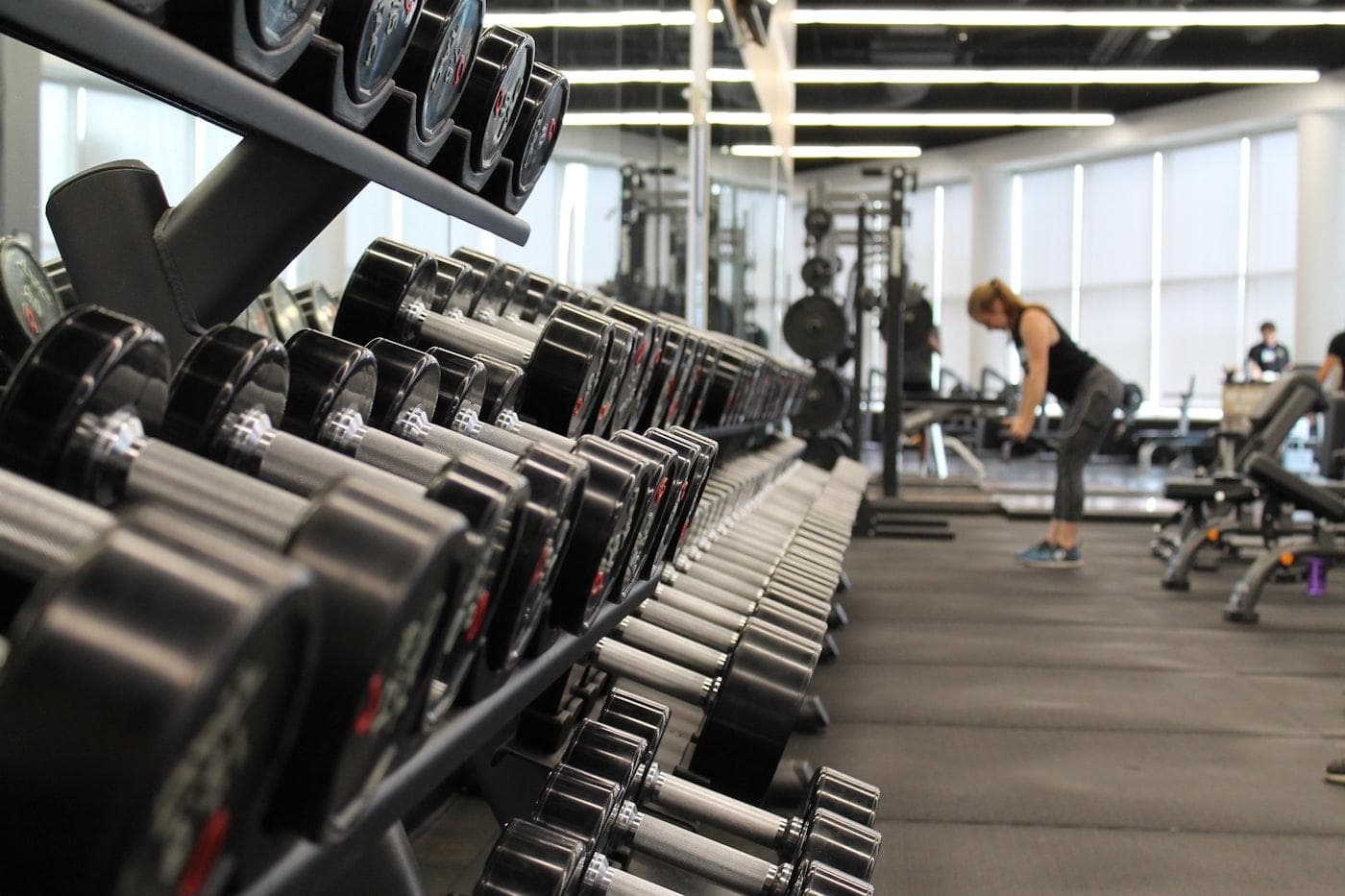 Modern gym floor with weight equipment and natural light