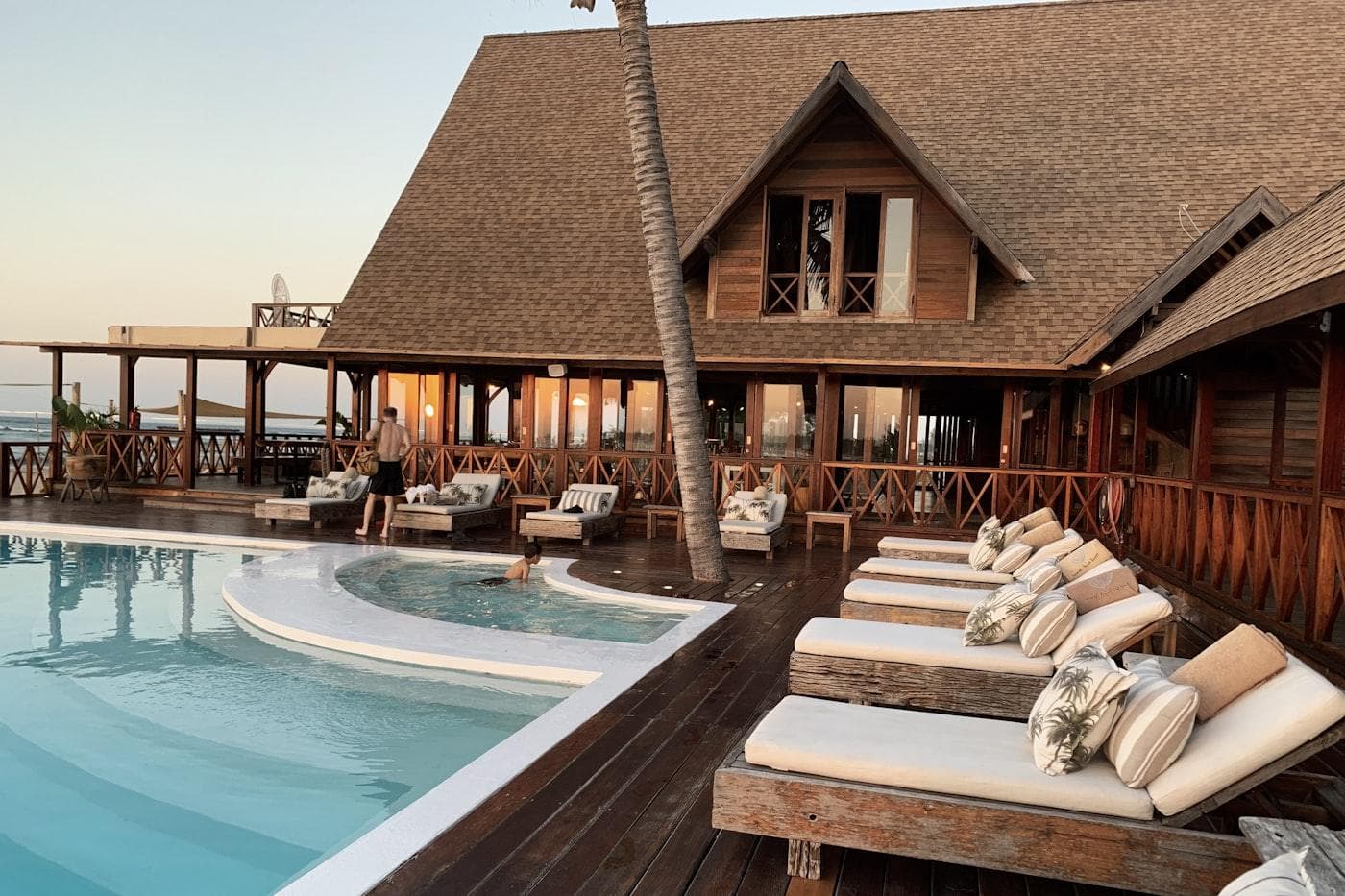 Hotel pool terrace with palm trees at sunset